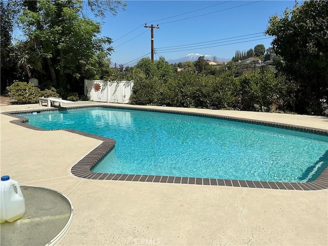view of swimming pool featuring a patio area, a diving board, a fenced in pool, and fence
