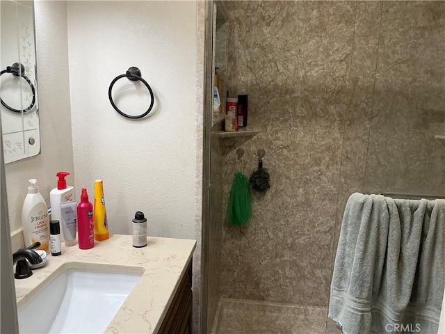 bathroom featuring walk in shower and vanity