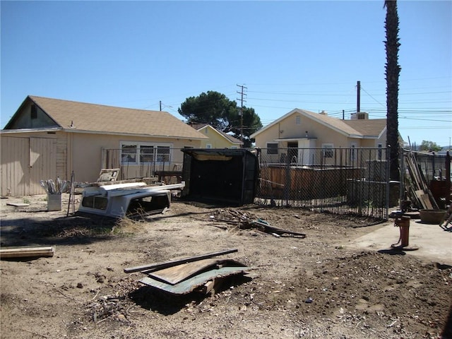 back of house with an outbuilding and fence