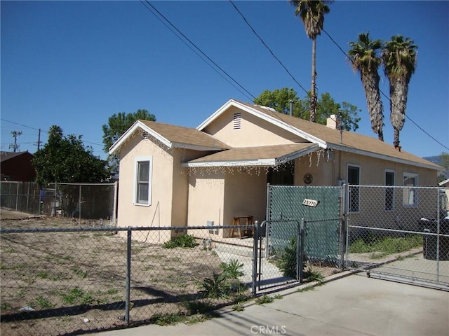 bungalow-style house featuring a gate, stucco siding, and fence