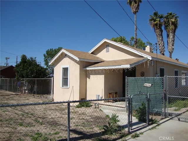 bungalow-style house featuring a gate, stucco siding, and fence