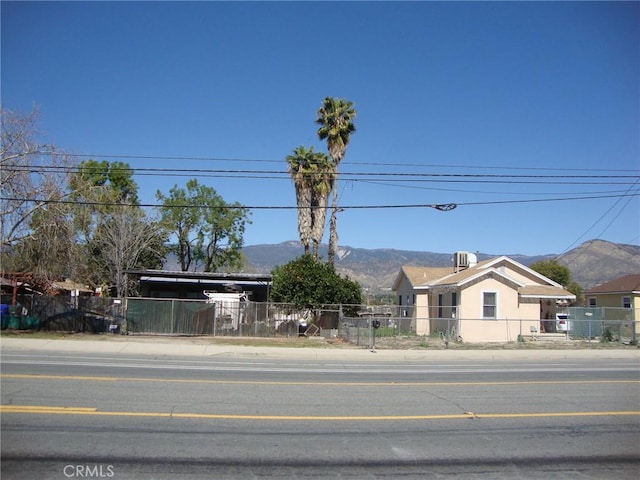 view of front facade featuring a mountain view and a fenced front yard