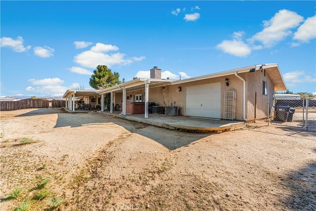 view of front facade featuring stucco siding, driveway, a patio, fence, and an attached garage