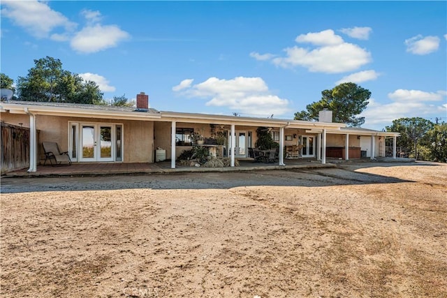 back of house featuring a patio area, french doors, and a chimney