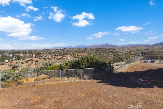 view of yard featuring a mountain view and fence