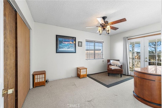 sitting room with carpet, a healthy amount of sunlight, french doors, and a textured ceiling