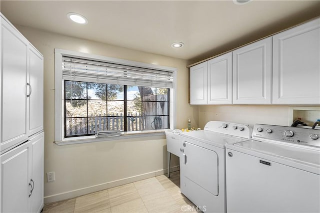 washroom with cabinet space, washing machine and dryer, baseboards, and a wealth of natural light