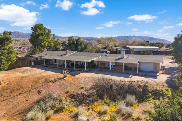 exterior space featuring a mountain view, an attached garage, and fence