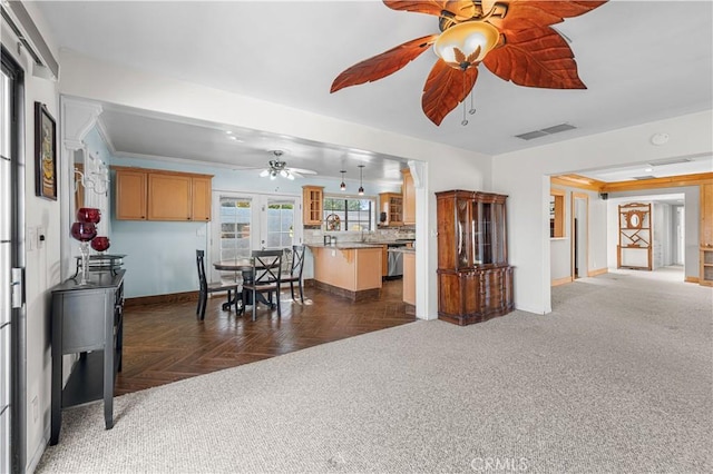 interior space with visible vents, open floor plan, light countertops, glass insert cabinets, and baseboards