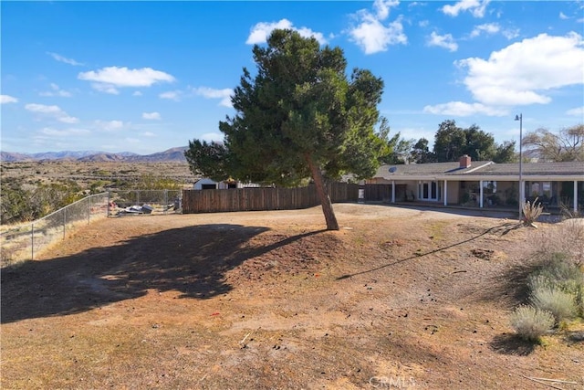 view of yard with fence and a mountain view