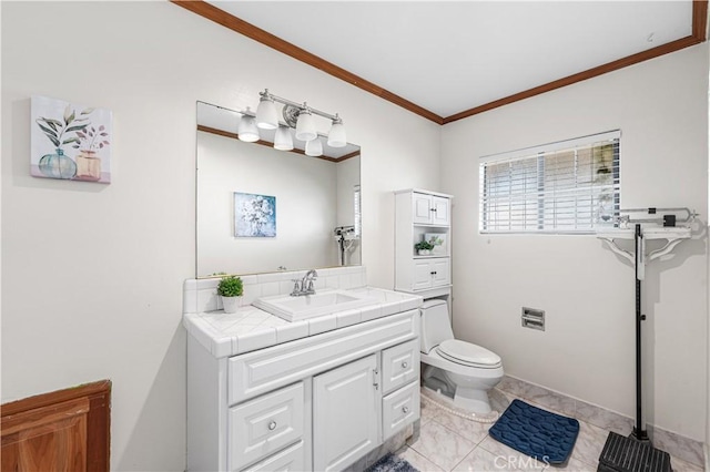 bathroom with vanity, crown molding, toilet, and baseboards