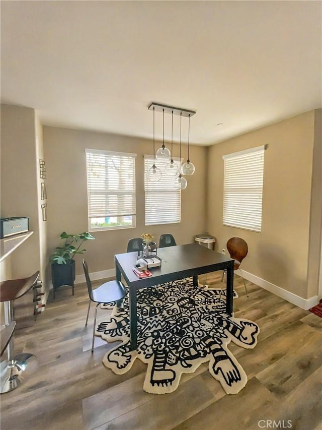 dining space with light wood-style floors and baseboards