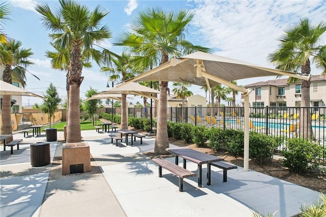 view of home's community with a pool and fence