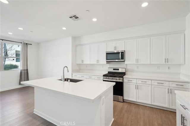 kitchen featuring light wood-type flooring, visible vents, appliances with stainless steel finishes, and a sink