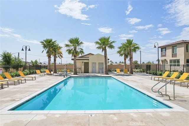 pool with a patio and fence