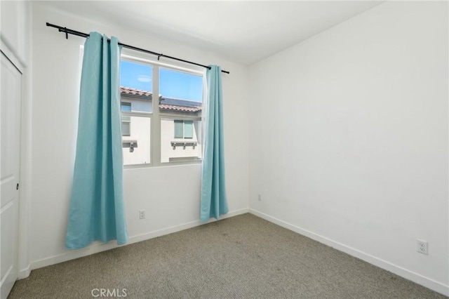 unfurnished room featuring baseboards and carpet