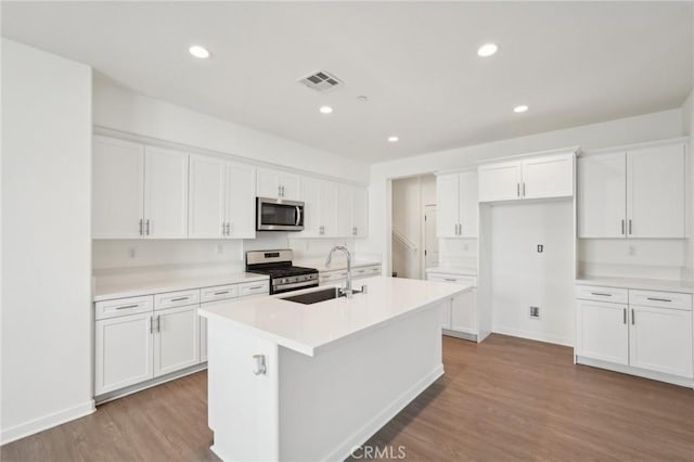 kitchen with visible vents, white cabinetry, stainless steel appliances, and a sink