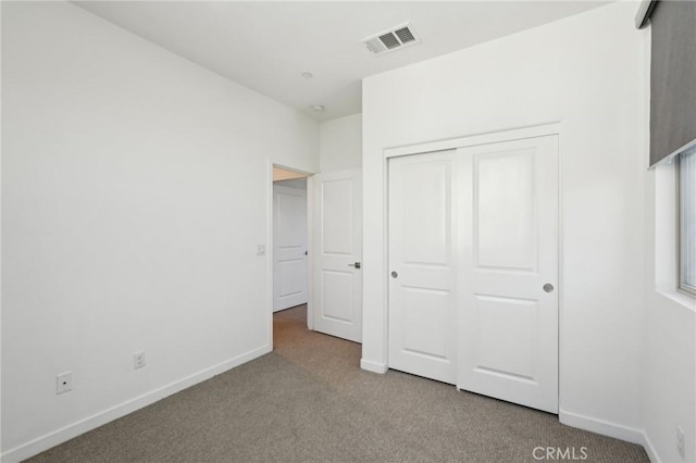 unfurnished bedroom featuring carpet flooring, baseboards, visible vents, and a closet