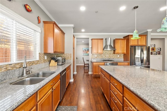 kitchen with dark wood-style floors, ornamental molding, a sink, appliances with stainless steel finishes, and wall chimney exhaust hood