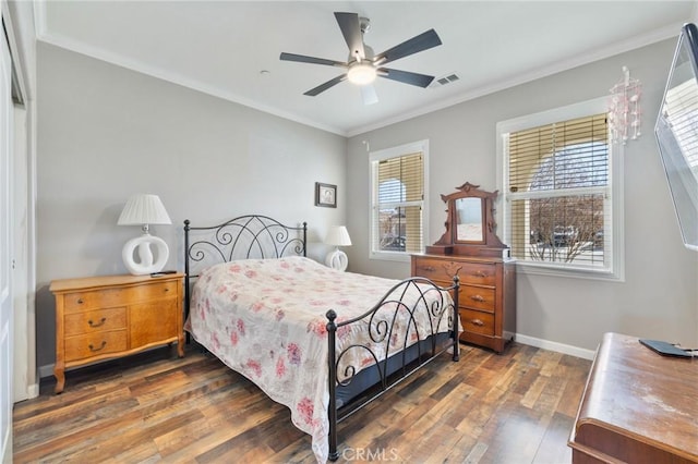 bedroom featuring visible vents, ceiling fan, baseboards, ornamental molding, and hardwood / wood-style floors