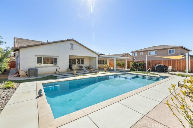 view of swimming pool featuring a patio area, central air condition unit, a fenced in pool, and fence