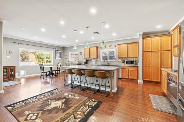 kitchen with visible vents, tasteful backsplash, a kitchen island, and dark wood-style flooring