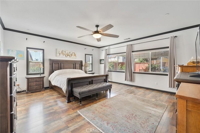 bedroom featuring visible vents, wood finished floors, baseboards, and ornamental molding