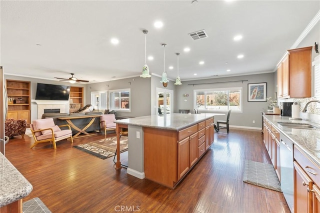 kitchen featuring visible vents, a sink, open floor plan, stainless steel appliances, and a tile fireplace