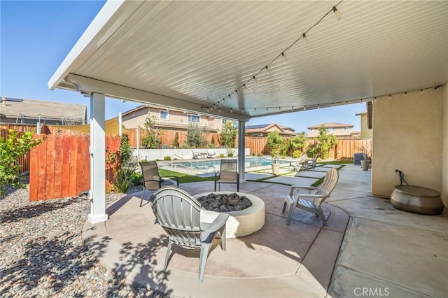 view of patio with a fenced in pool, a fire pit, and a fenced backyard