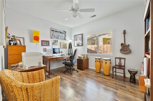 home office with ceiling fan, visible vents, baseboards, and wood finished floors