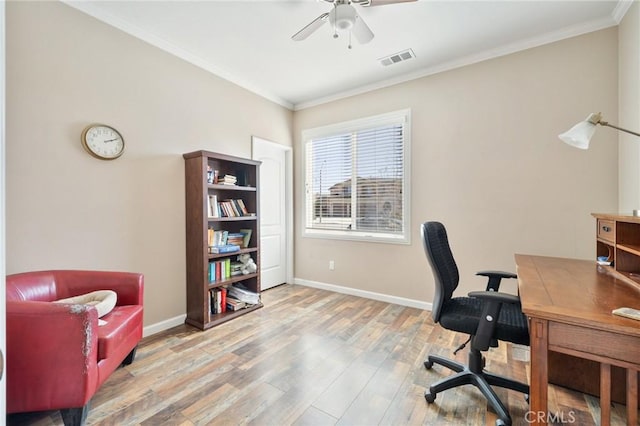 office space with wood finished floors, baseboards, visible vents, ceiling fan, and ornamental molding