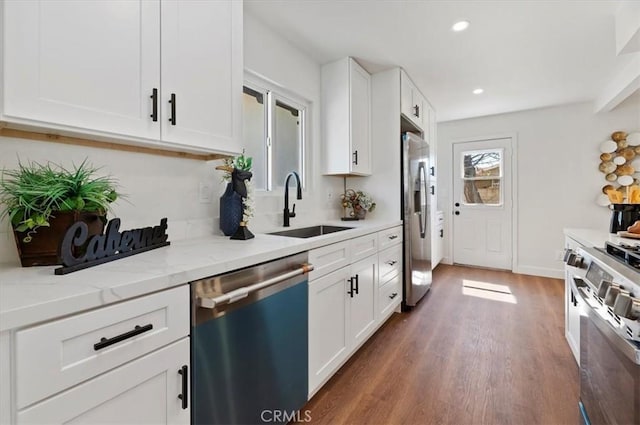 kitchen featuring dark wood-style floors, white cabinets, stainless steel appliances, and a sink