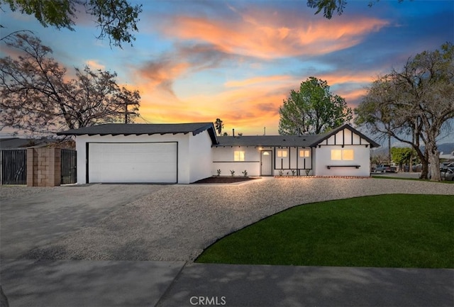 view of front of property featuring a front yard, a garage, and driveway