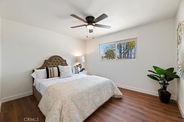 bedroom featuring baseboards, wood finished floors, and a ceiling fan