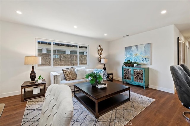 living room with recessed lighting, visible vents, baseboards, and wood finished floors