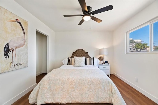 bedroom featuring dark wood-style floors, a ceiling fan, and baseboards