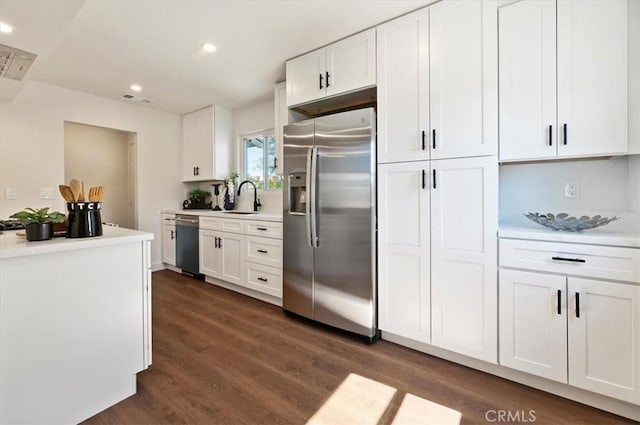 kitchen featuring a sink, white cabinetry, stainless steel fridge with ice dispenser, dishwashing machine, and dark wood-style flooring