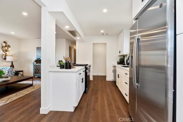 kitchen with recessed lighting, dark wood-style flooring, stainless steel appliances, light countertops, and white cabinetry