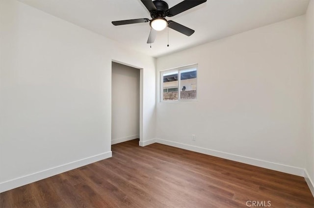 unfurnished room with ceiling fan, baseboards, and wood finished floors