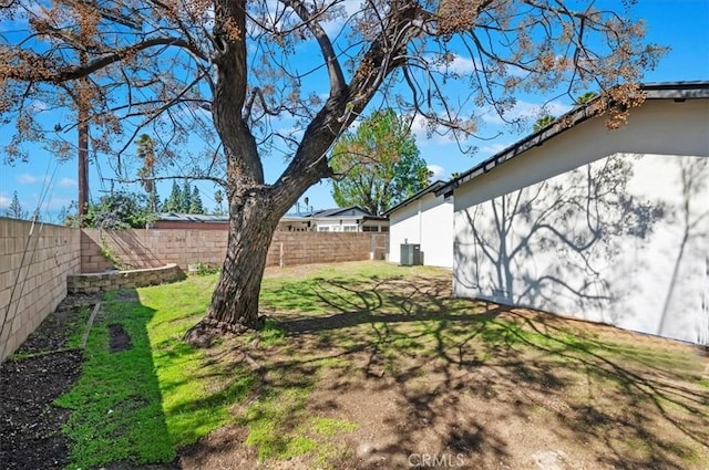 view of yard with central AC and a fenced backyard