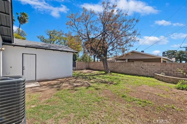 view of yard featuring central AC unit and fence