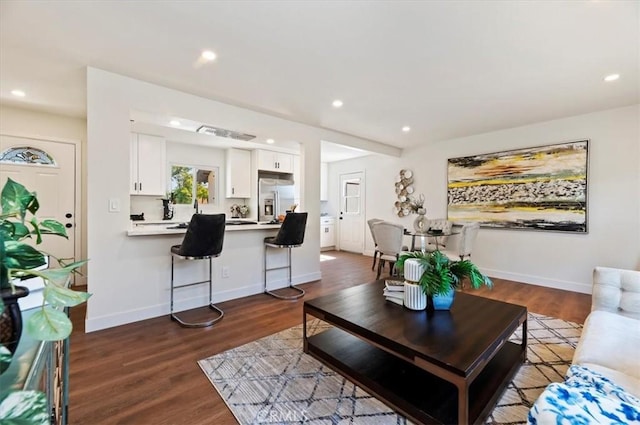 living area featuring recessed lighting, baseboards, and wood finished floors