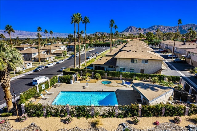 pool featuring a patio area, a mountain view, and fence