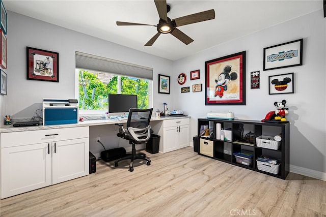 office space featuring baseboards, ceiling fan, and light wood finished floors