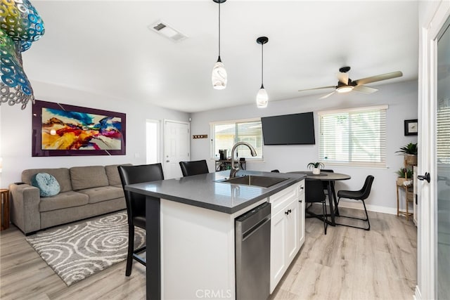 kitchen featuring dark countertops, visible vents, a sink, white cabinetry, and stainless steel dishwasher