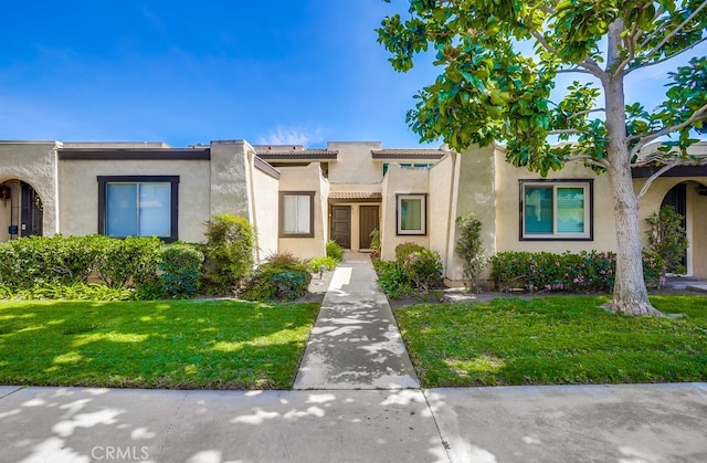 view of front of property with a front yard and stucco siding