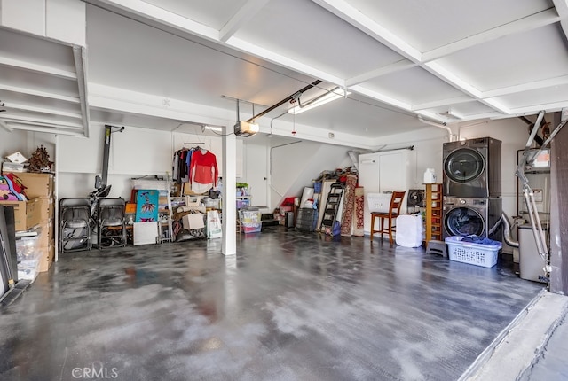 garage featuring stacked washer / drying machine and a garage door opener