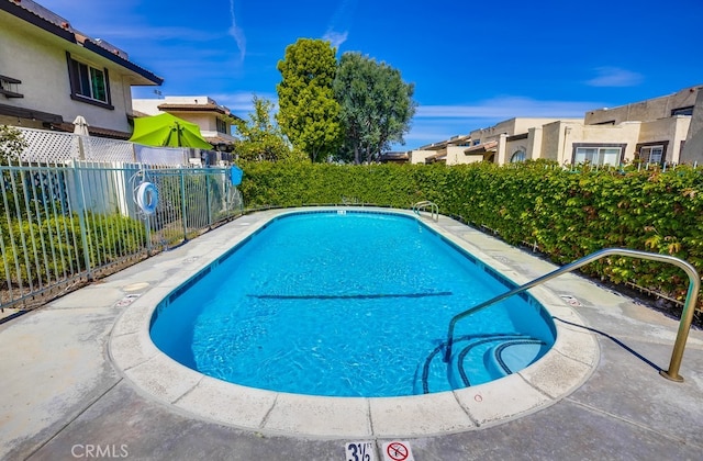 community pool with a fenced backyard