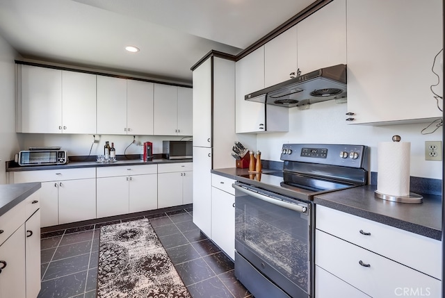 kitchen featuring dark countertops, white cabinets, stainless steel appliances, and custom range hood