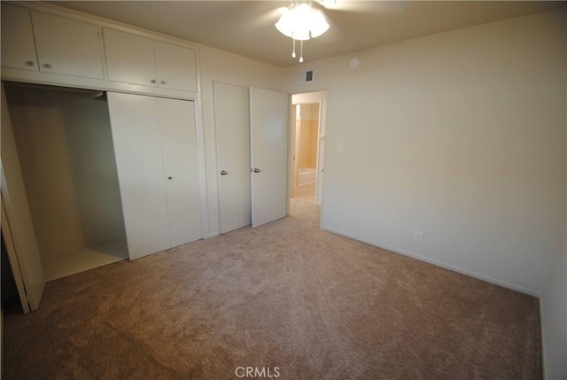 unfurnished bedroom featuring visible vents, a closet, and light carpet